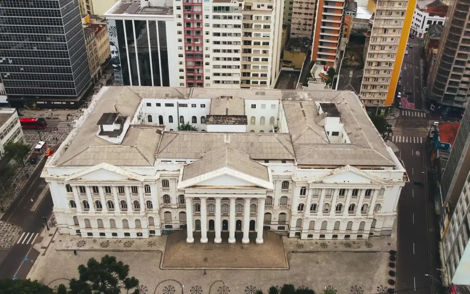 A historic civic building among city towers, seen from above